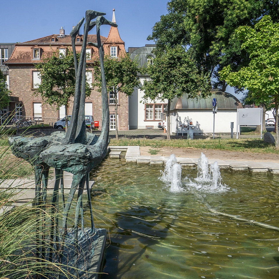 Brunnen mit vier Fontainen und Flamingo-Skulpturen, dahinter das Ohlystift in Gräfenhausen