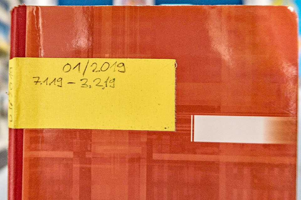 Man sieht die obere Hälfte eines roten Notizbuchs mit einem gelben Aufkleber, der zeigt dass im Buch Sachen aus der Zeit zwischen 7.1. und 3.2.2019 notiert wurde.
