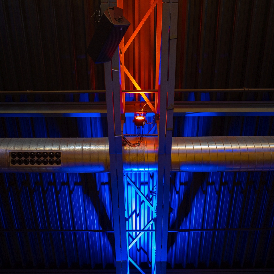 Blaue und rote LED-Strahler beleuchten eine Stahlträgerkonstruktion unterm Dach der Centralstation im obenen Saal.